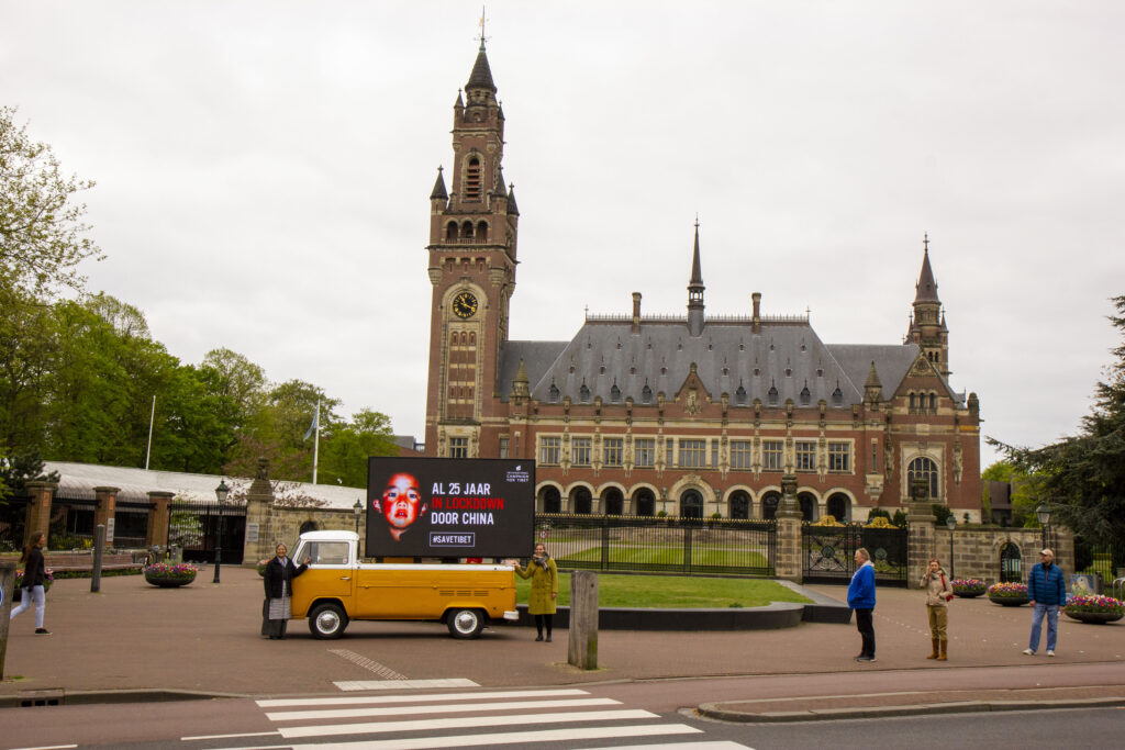 Banner: 'Al 25 jaar in lockdown door China' voor het Vredespaleis in Den Haag